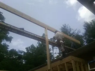 Carpenter setting a ridge beam over a new addition frame — Ice Dam Removal by Roofing Brothers in Woodridge