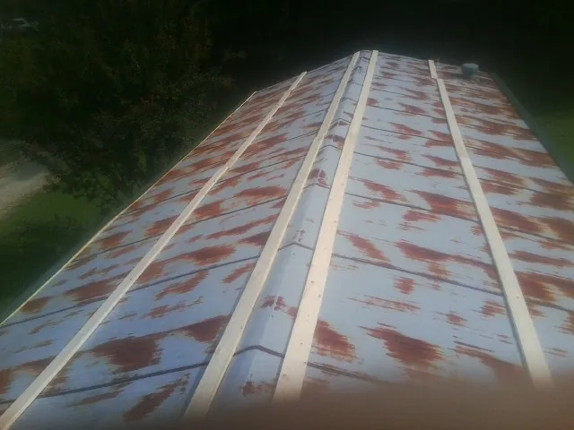 Rusted metal roof panels with new wood purlins before replacement — Storm Damage Roof Repair in Woodridge by Roofing Brothers