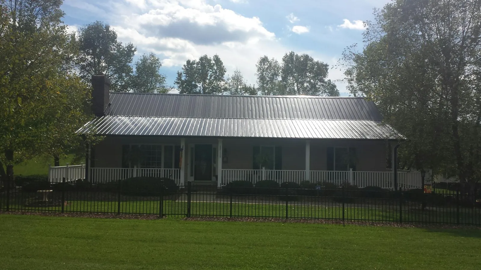 Gray metal roof on a brick ranch with a full width front porch — Gutter Guard Installation work by our crew in Woodridge