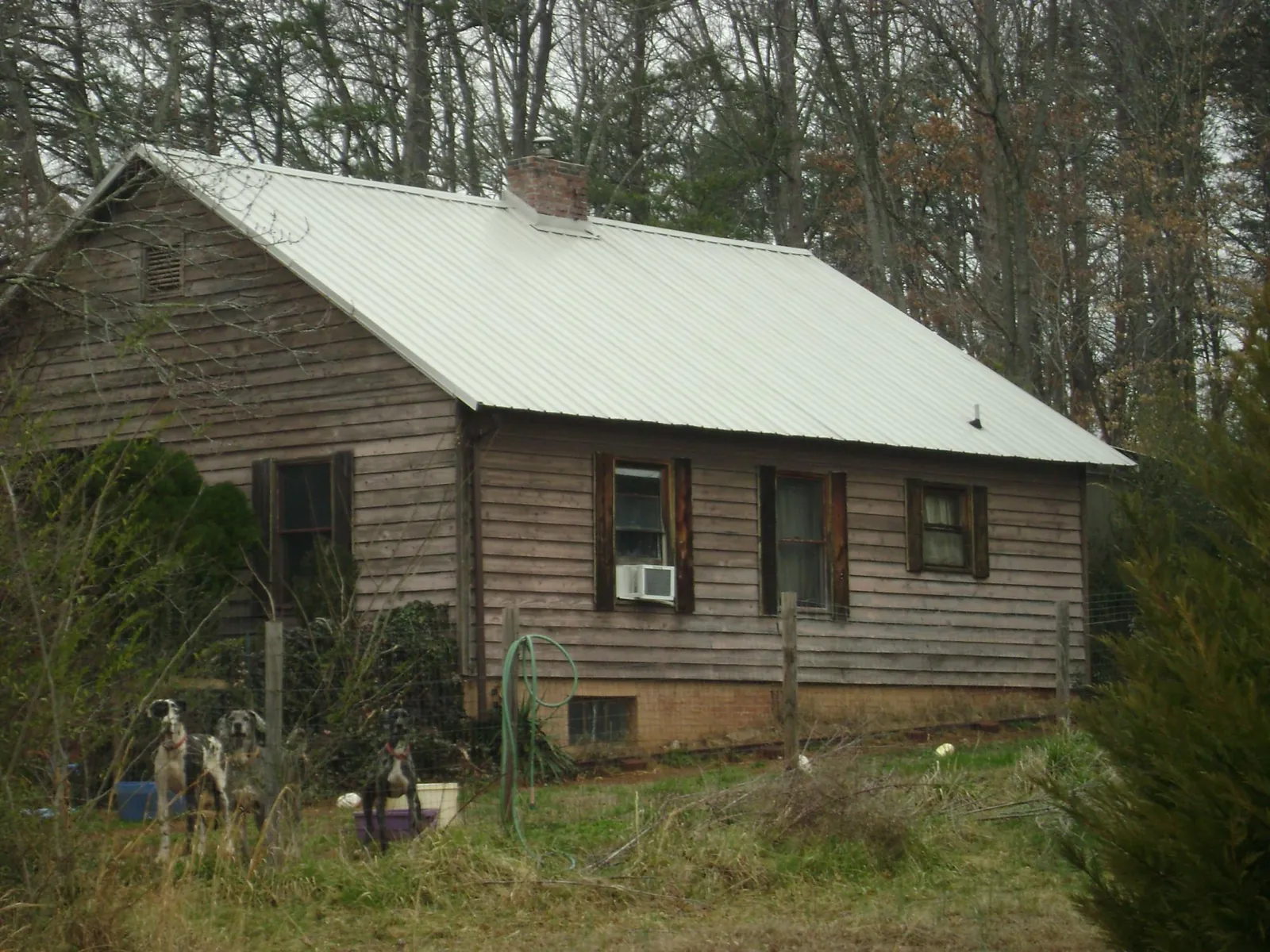 White metal roof on an old wood sided farmhouse, from a Metal Roof Installation job in Woodridge